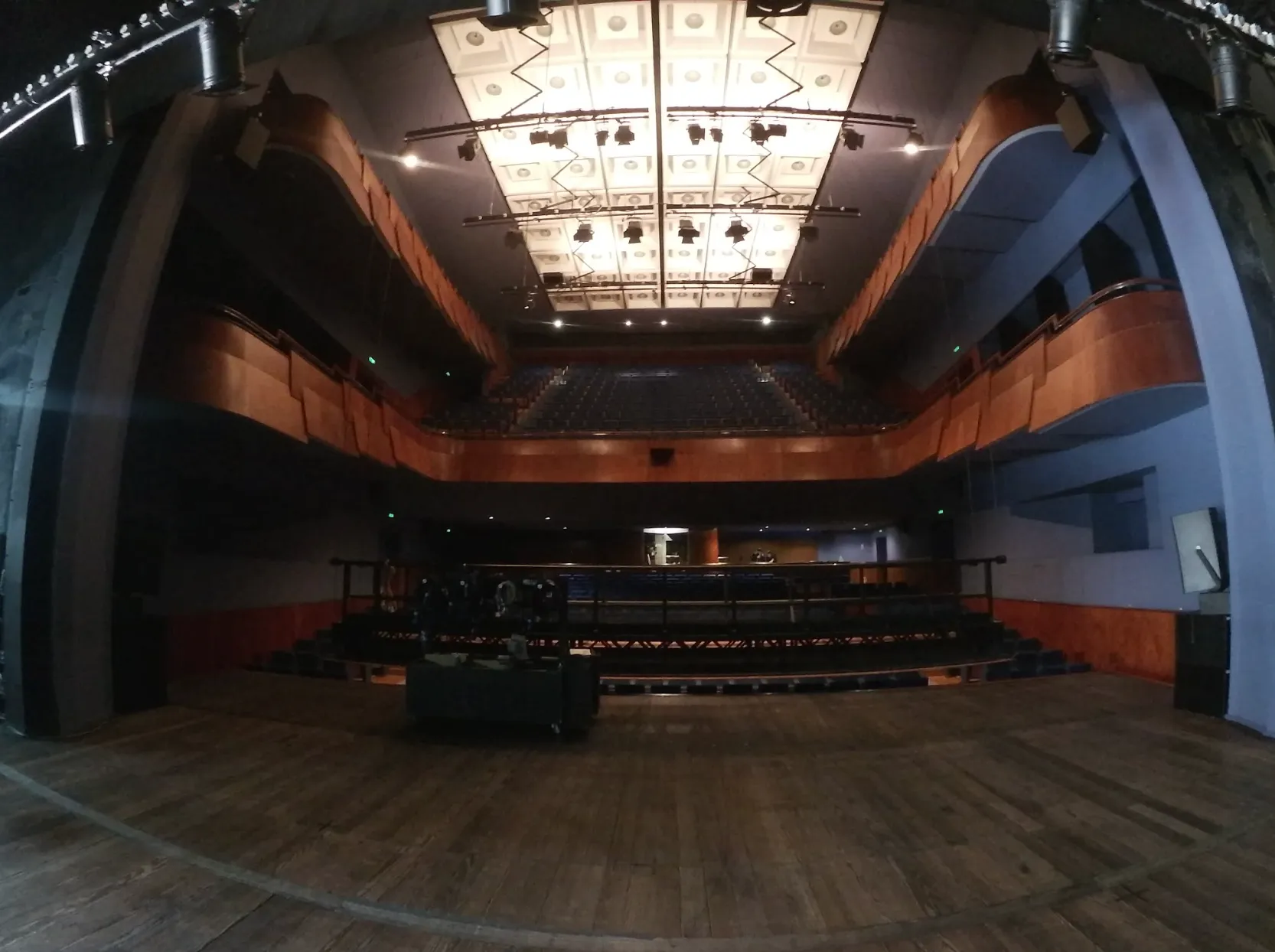 Interior de teatro clássico visto do palco, plateia e balcões em perspetiva