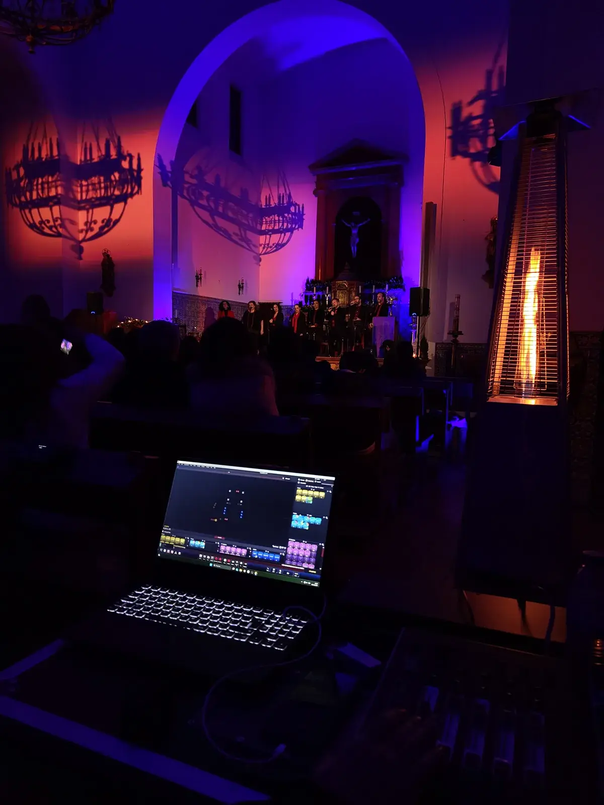 Operação de luz em concerto numa igreja com laptop e software de iluminação em primeiro plano